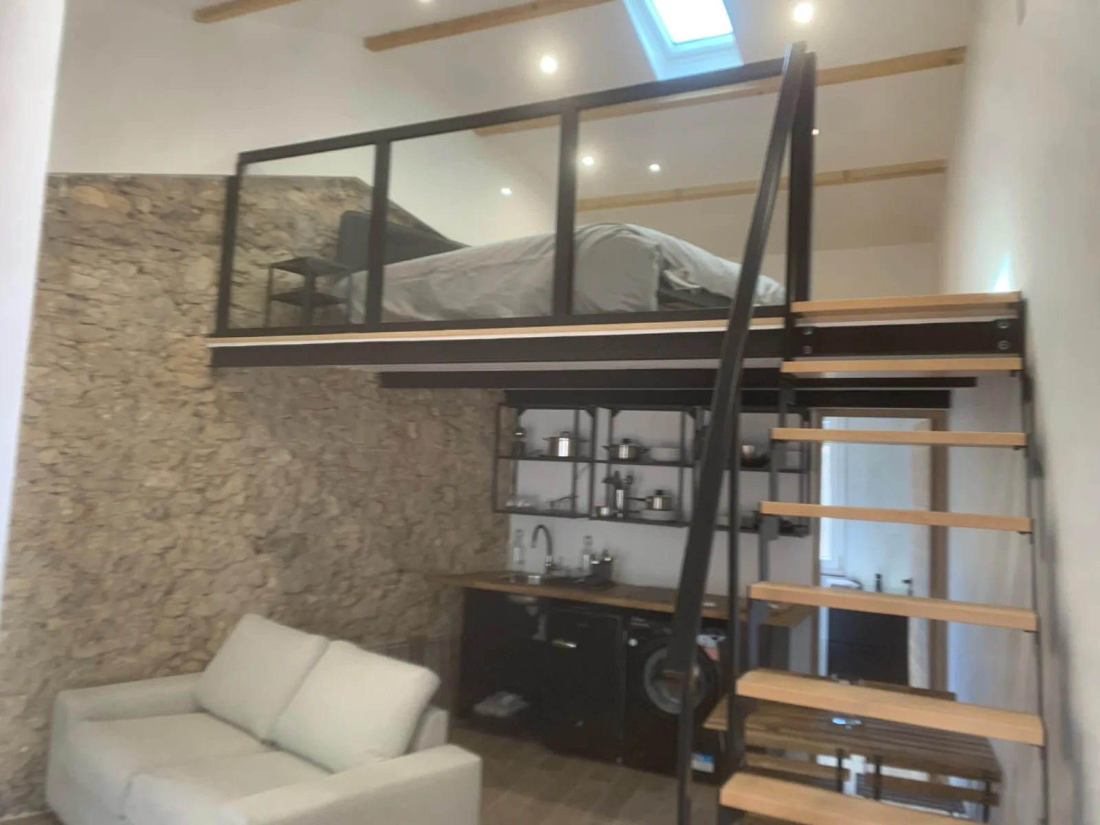 Séjour avec mezzanine, escalier en bois et garde-corps vitré